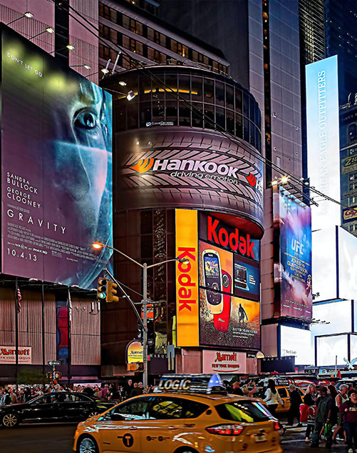 A busy intersection with billboards is shown. 